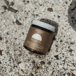 Jar of Genesis Magnesium tallow product on a textured surface