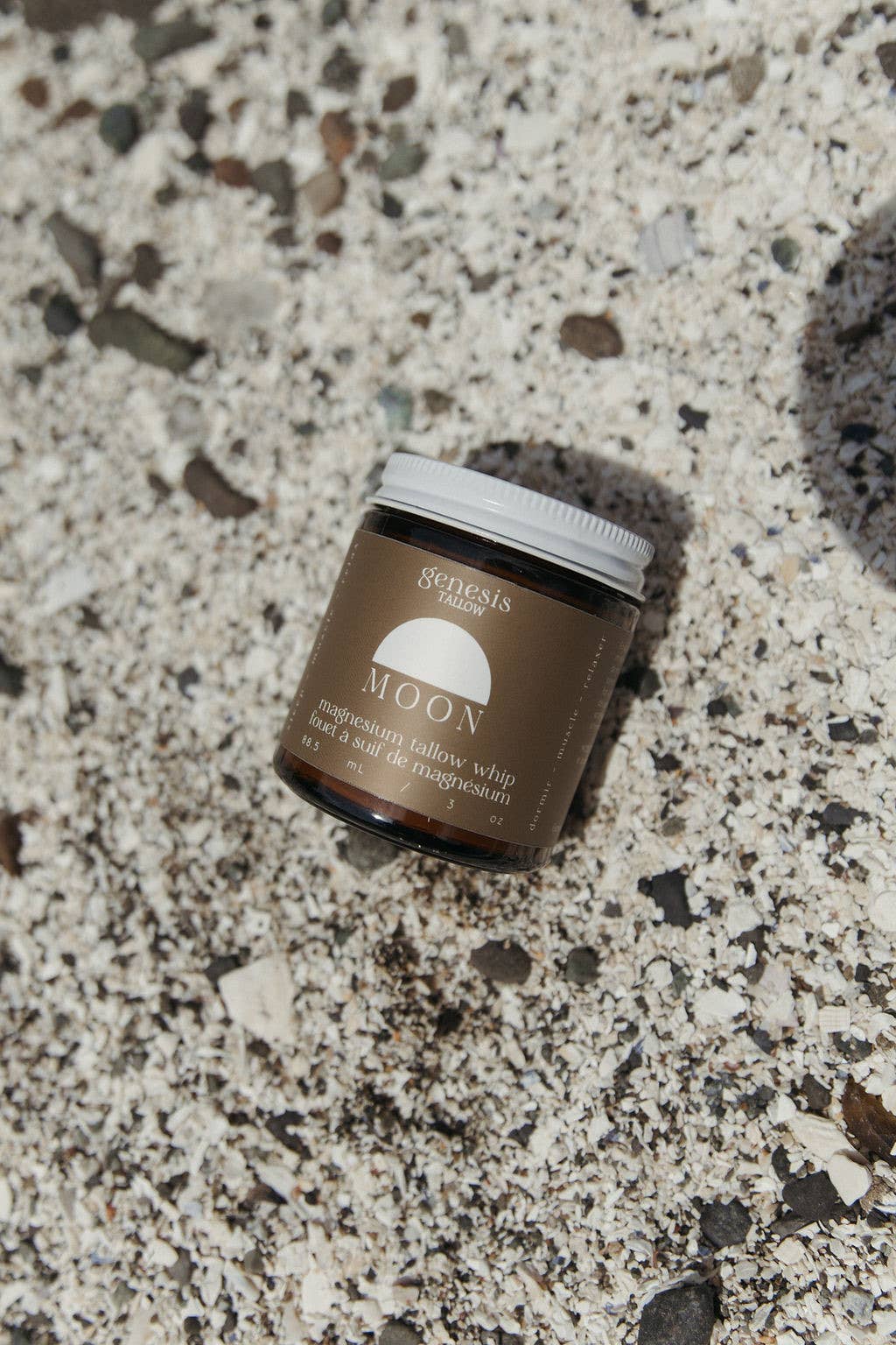 Jar of Genesis Magnesium tallow product on a textured surface