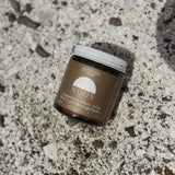 Jar of Genesis Magnesium tallow product on a textured surface