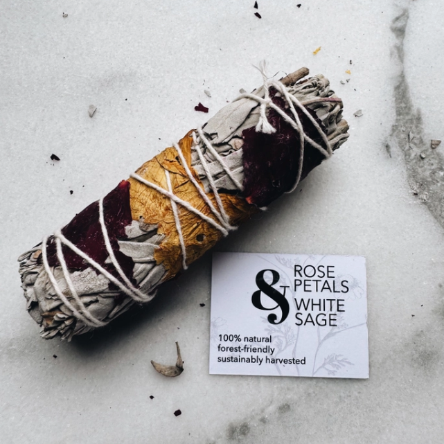 Rolled sage bundle with a label on a textured surface