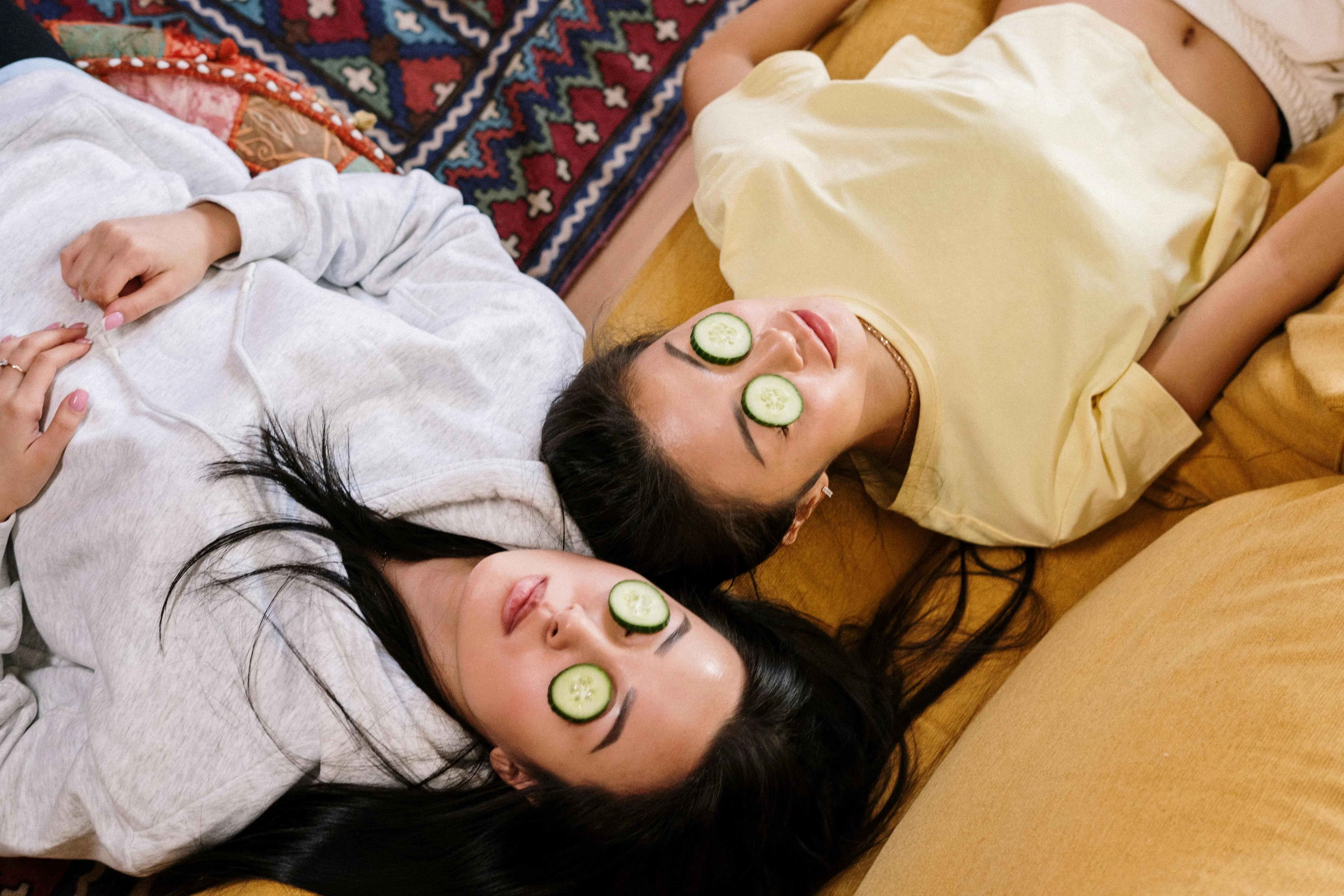 Women laying down with Green Beauty Curator face mask on 
