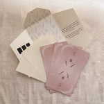 Set of pink Homebound Tarot cards with icons on a textured surface