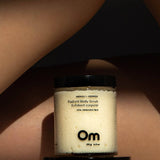 Jar of Om Organics body scrub on a person's skin