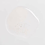 Om Organics body oil Clear oil-like substance with small particulates on a light gray background
