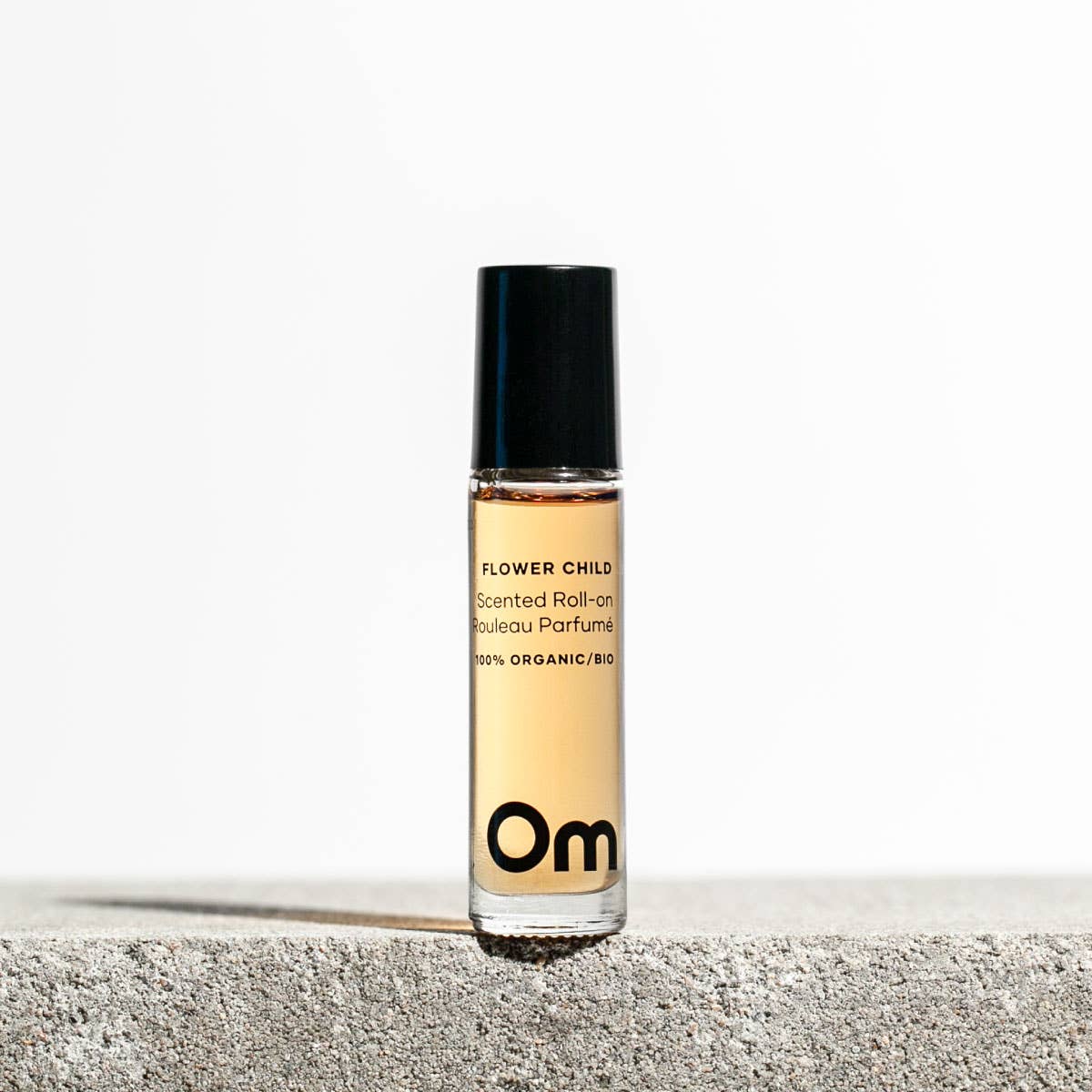 Om Organics Roll-on perfume bottle labeled 'Om' on a light background