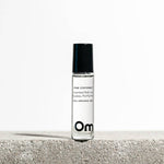Roll-on perfume bottle labeled 'Pink Coconut' by Om Organic Skincare on a light background