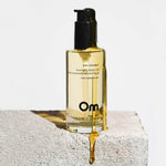 Bottle of Om pink coconut aromatherapy body oil on a light background