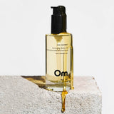 Bottle of Om pink coconut aromatherapy body oil on a light background