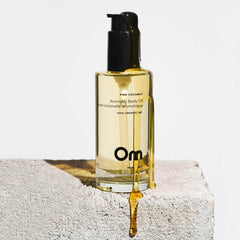 Bottle of Om pink coconut aromatherapy body oil on a light background