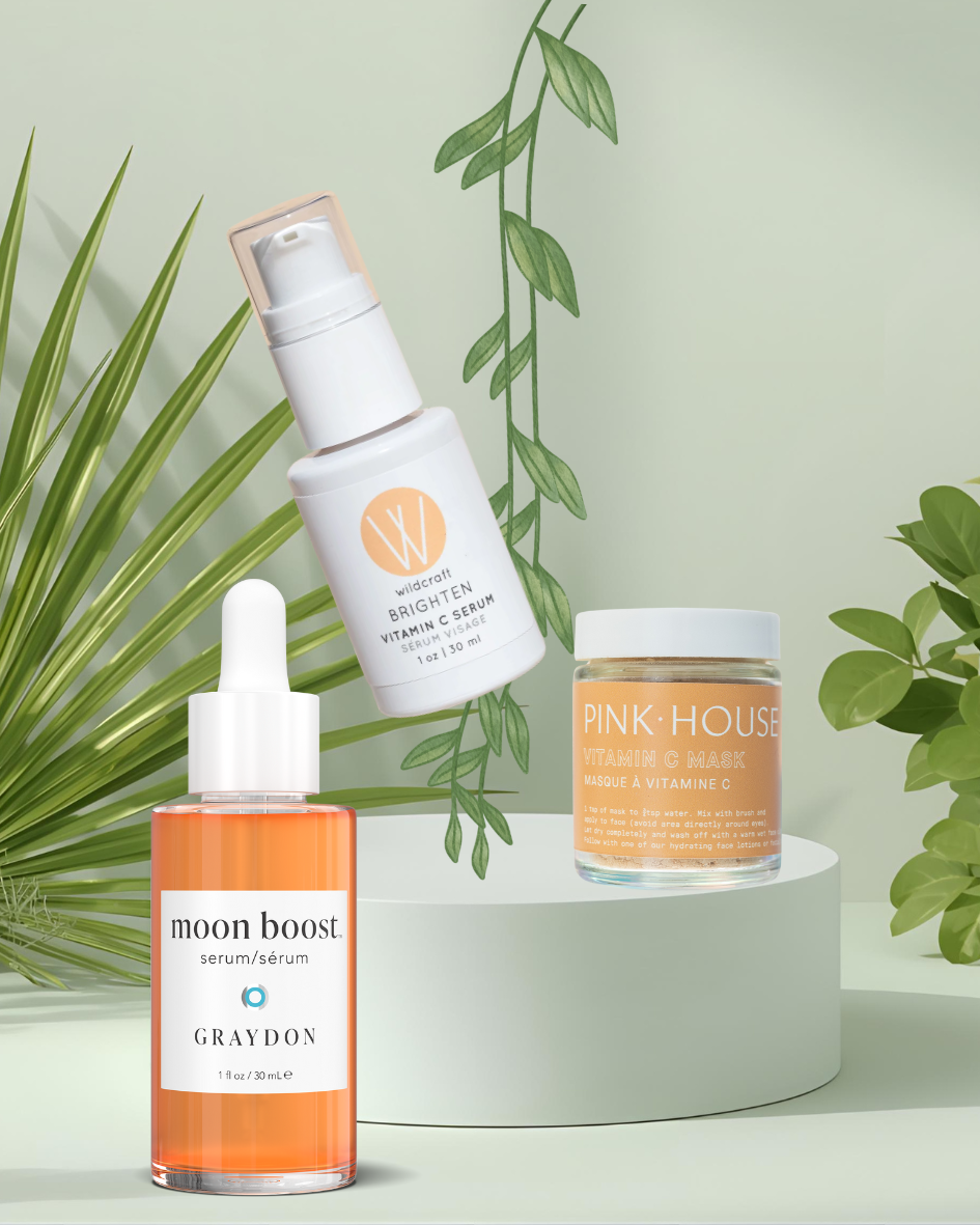 Three Green Beauty Curator skincare products on a white stand with green leaves in the background