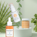 Three Green Beauty Curator skincare products on a white stand with green leaves in the background