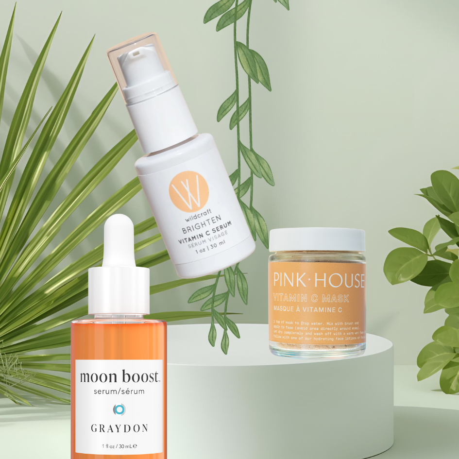 Three Green Beauty Curator skincare products on a white stand with green leaves in the background