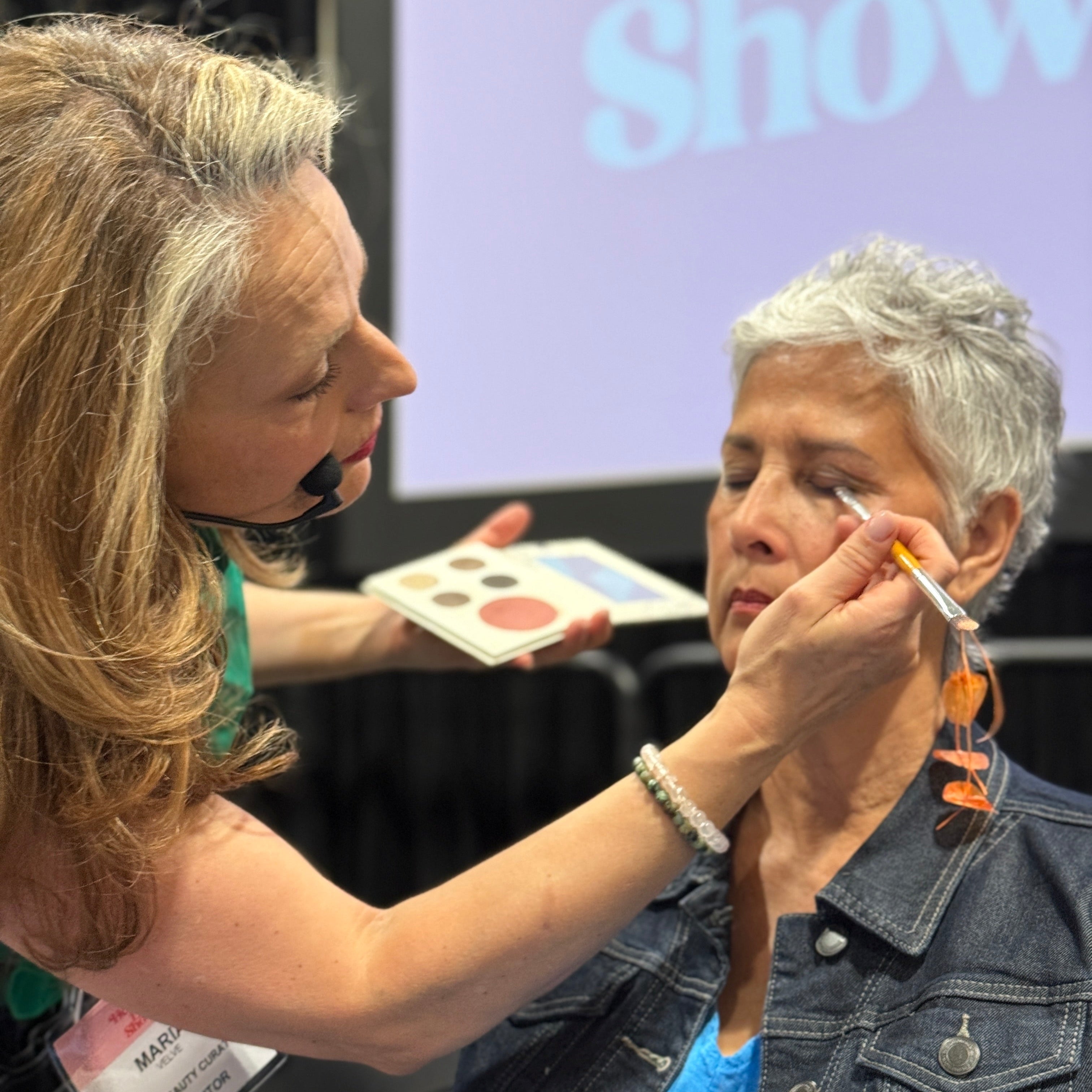Maria Velve applying makeup to 40+ woman at a live show.