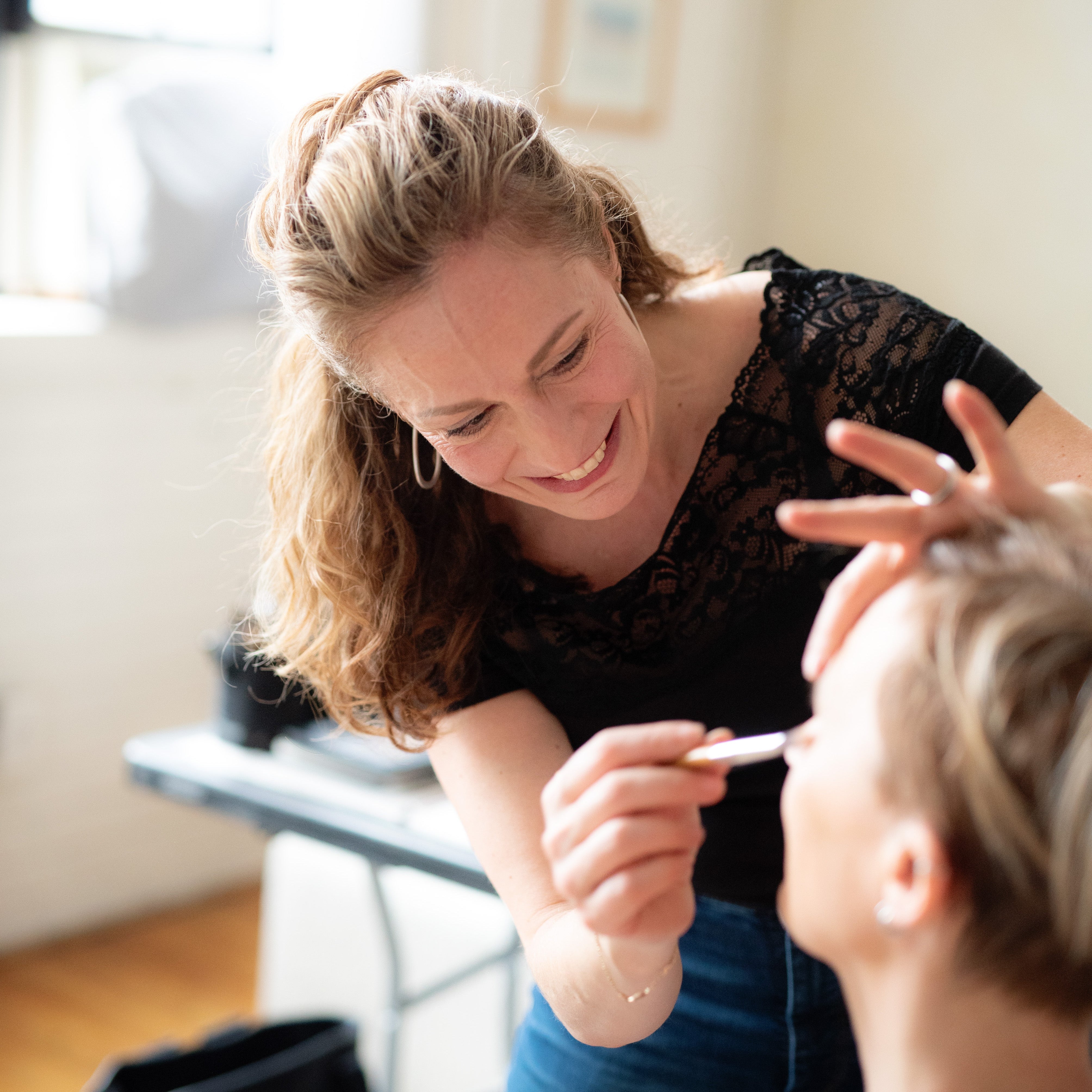 Maria Velve applying makeup to a woman 40+.