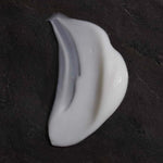 OM Organics Coconut Dew Cream White cream texture on a dark textured background.