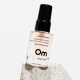 OM Organics Pink coconut hydrating face mist bottle with black cap on a white background