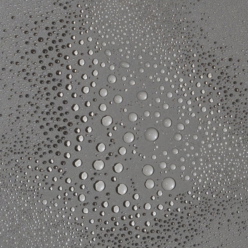 Close-up of OM Pink Coconut mist droplets on a gray surface