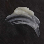 Close-up of OM Organics cleansing balm on a dark background