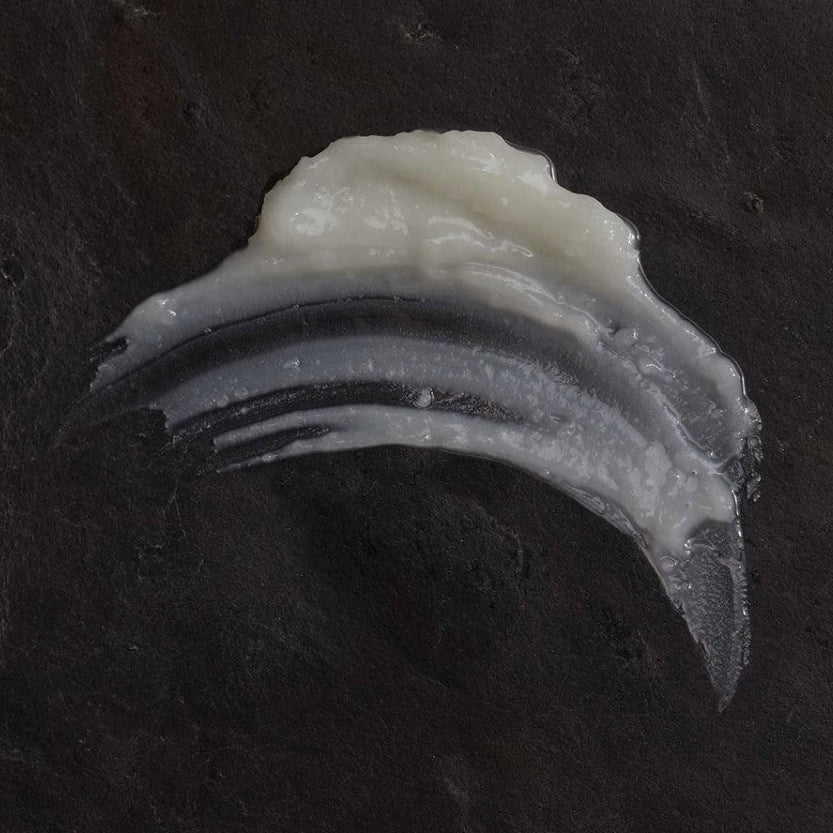 Close-up of OM Organics cleansing balm on a dark background