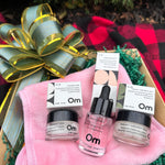 OM Organics skincare set on a pink towel and plaid fabric background
