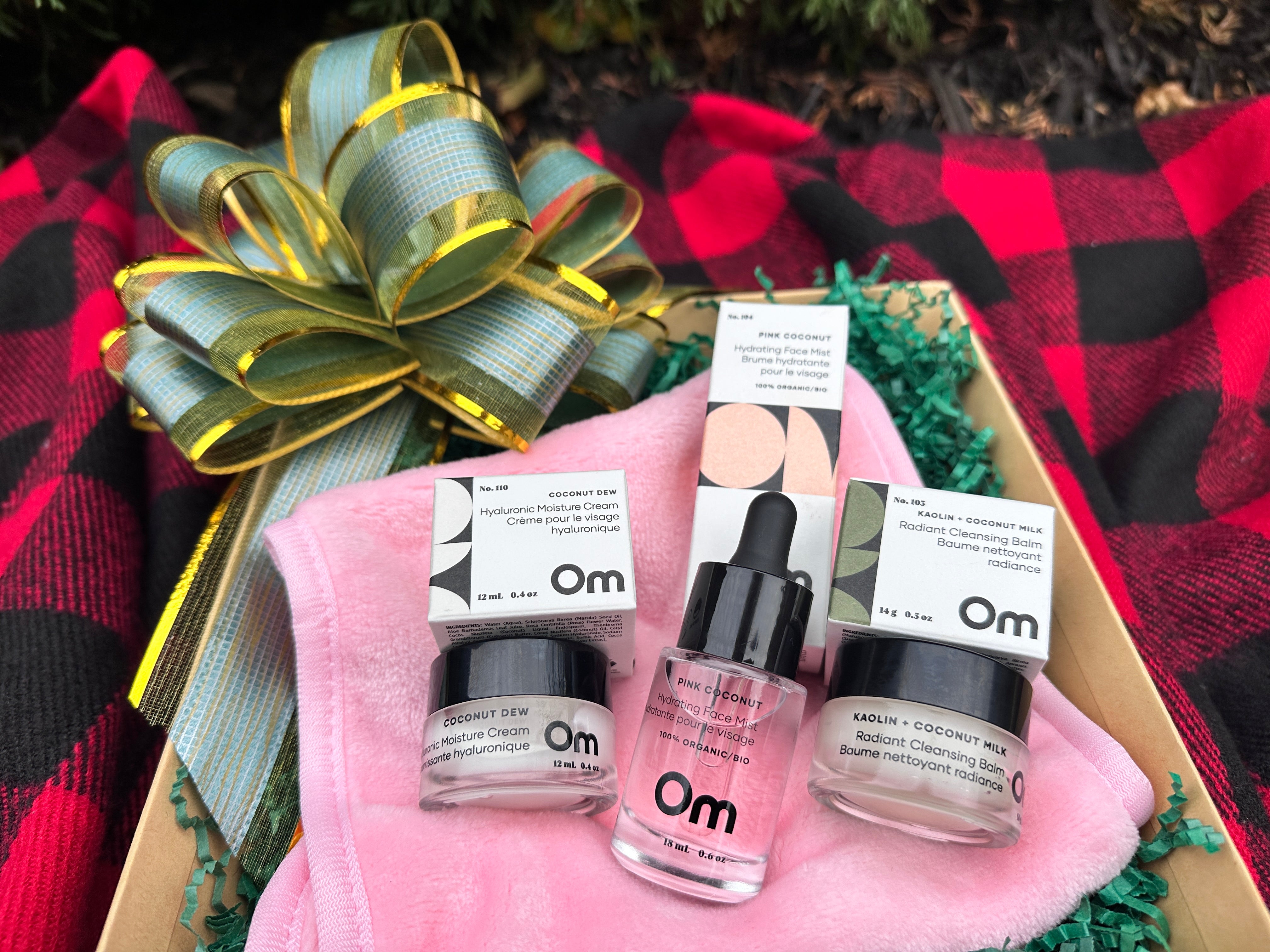 OM Organics skincare set on a pink towel and plaid fabric background