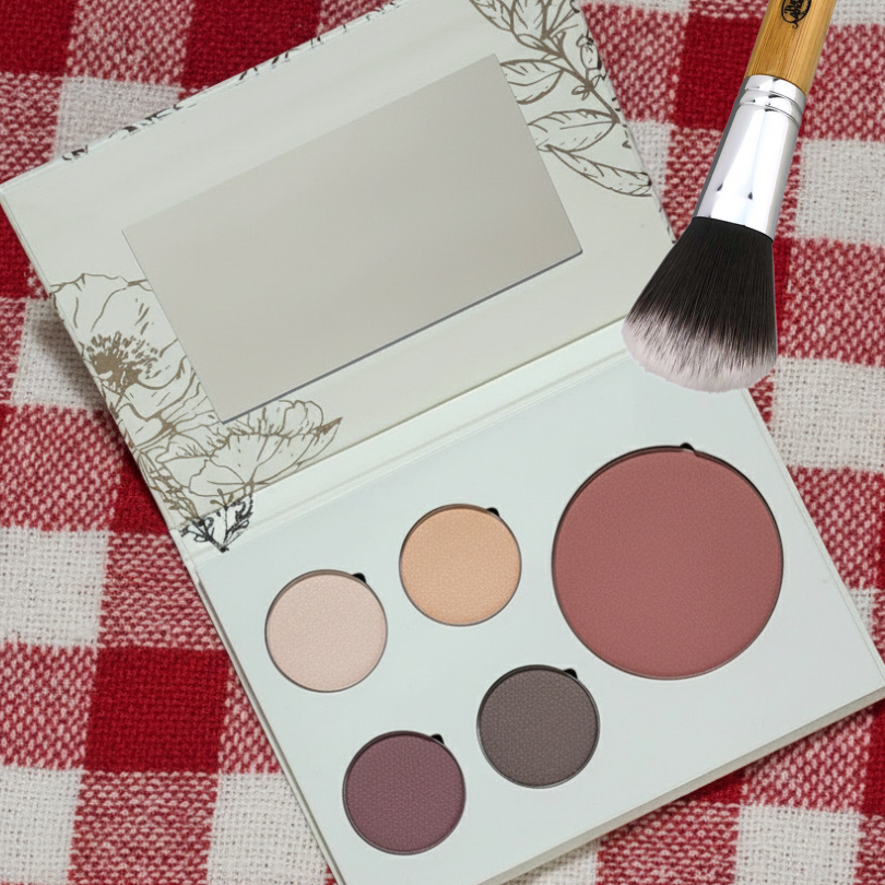 Pure Anada Makeup palette with four colors and a brush on a red and white checkered tablecloth