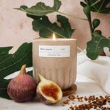 Mimi and August Candle with a label, figs, and leaves on a light background