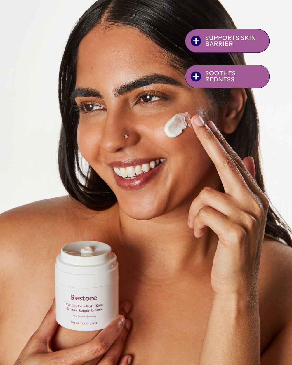 Woman applying Three Ships Restore cream to her face 