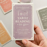 Hand holding a tarot card from Homebound tarot on a light background.