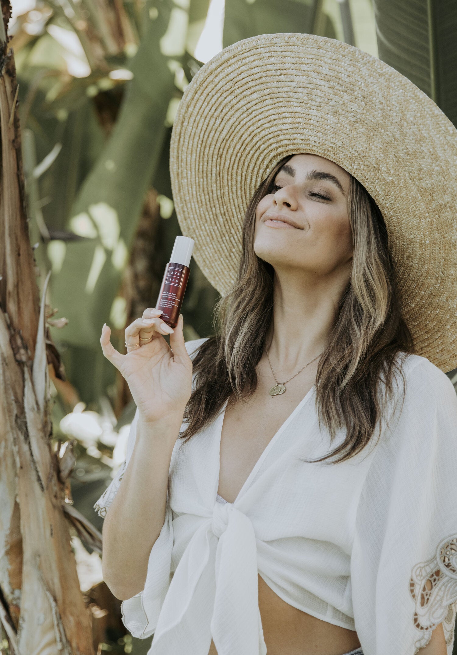 Young woman with Ava Isa Sun to Serum Drops
